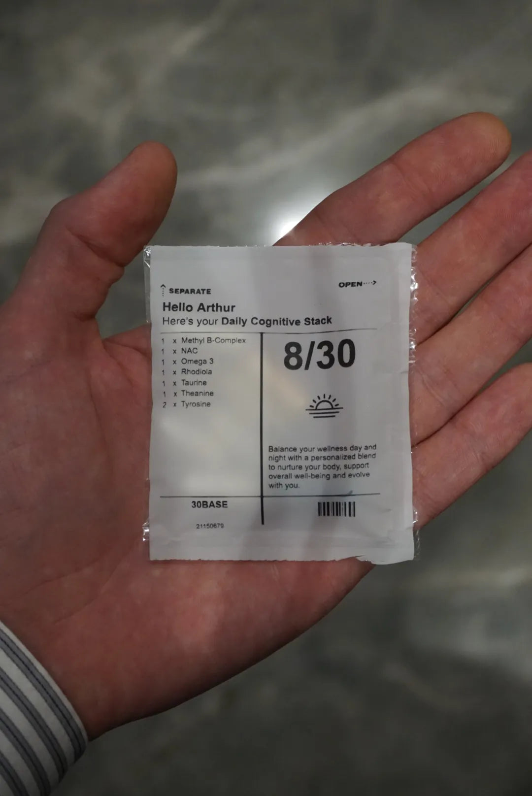A hand holding one 30BASE daily sachet printed with the day count.