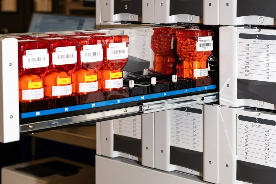 Trays of labeled, barcoded compound modules, each ingredient in its own module, at the production facility.