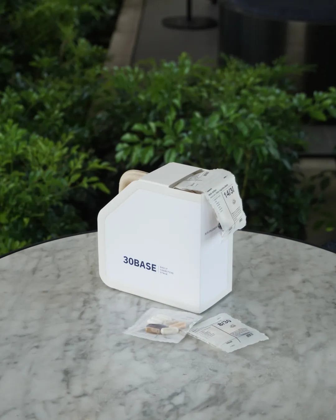 A 30BASE Daily Cognitive Stack box on a marble table with a daily sachet pulled from the dispenser opening