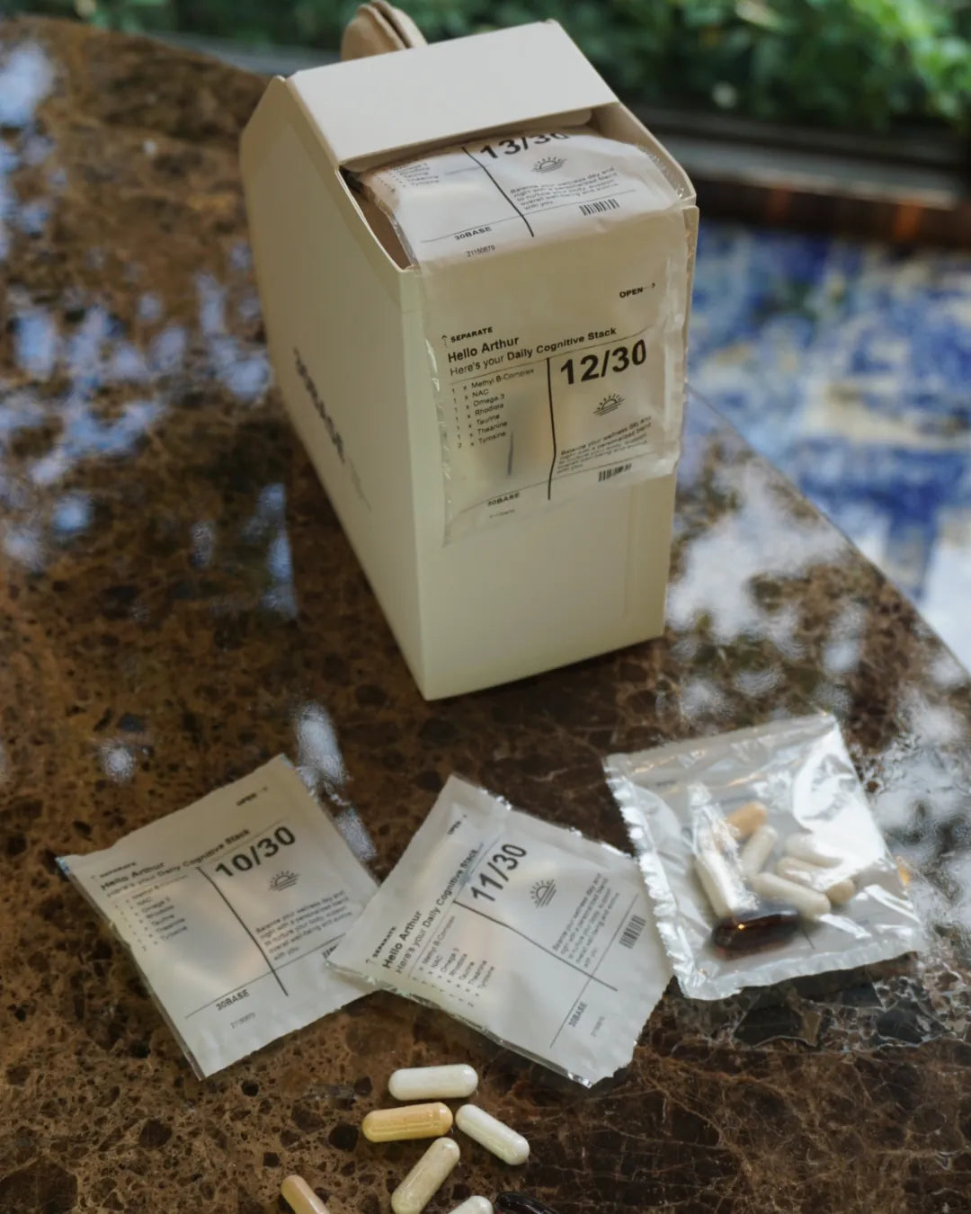 A 30BASE box on a ledge with an opened daily sachet and its eight capsules